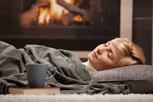 Woman sleeping beside fireplace